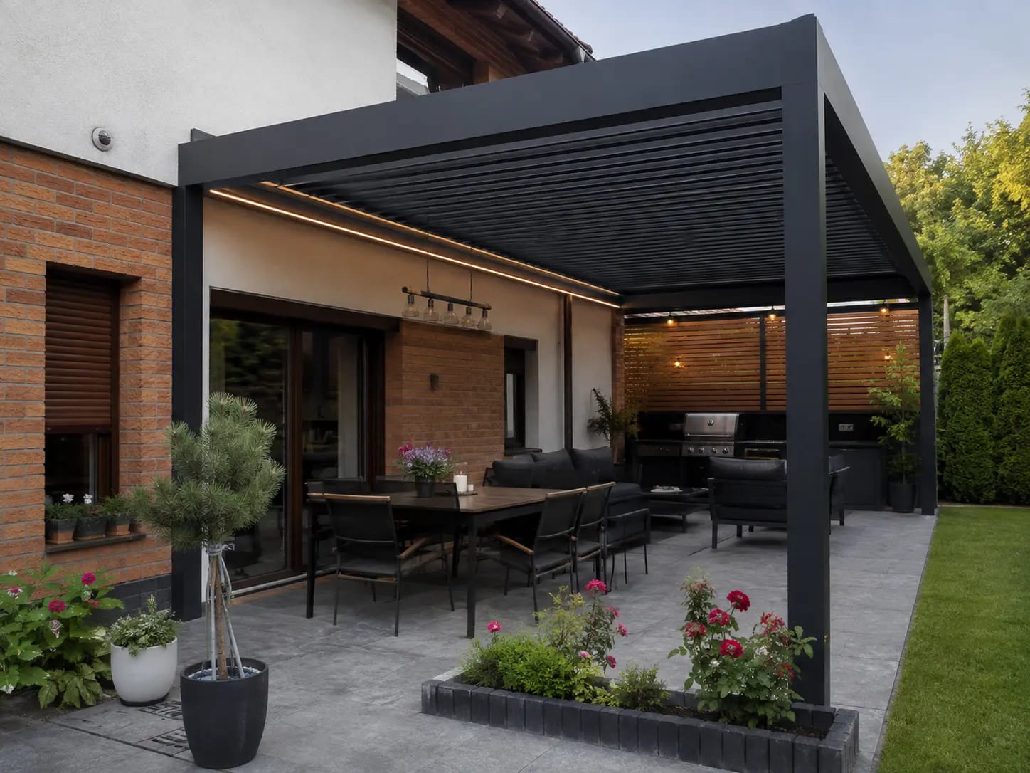 Pergola bioklimatyczna SB4000 przy elewacji domu jednorodzinnego z sofami ogrodowymi